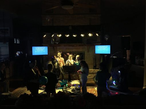 People having fun singing karaoke in front of two displays